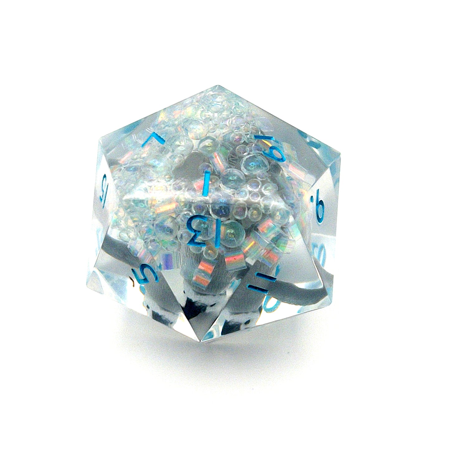 Clear resin D20 chonk showing the 1 face, with a toy penguin inside. The chonk has iridescent mylar tubes and glitter at the bottom, and is inked in ice blue
