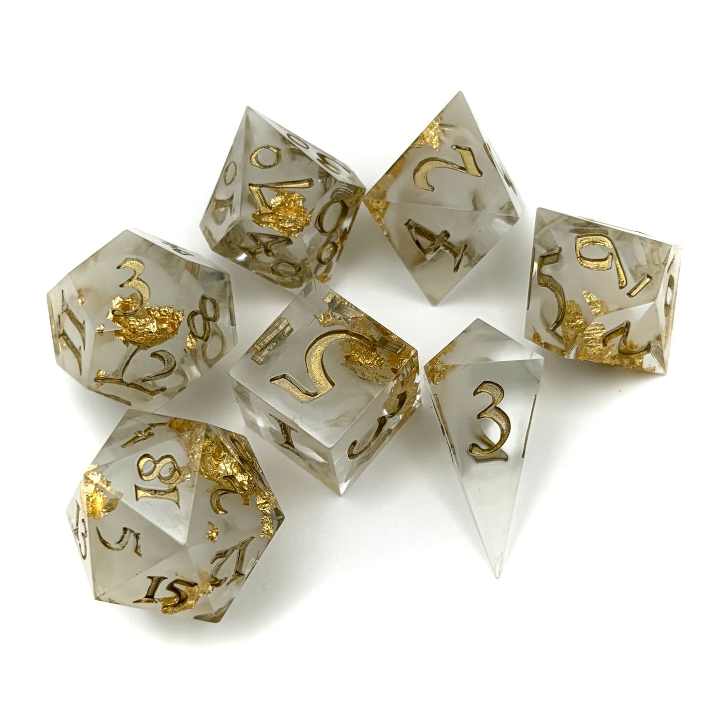Cloudy white resin dropped into clear resin, with gold flakes. Inking is Gold
