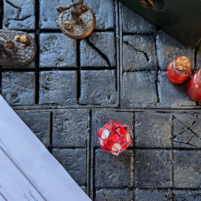 Blood in the water style death saves dice with white and red inking on a D&D background