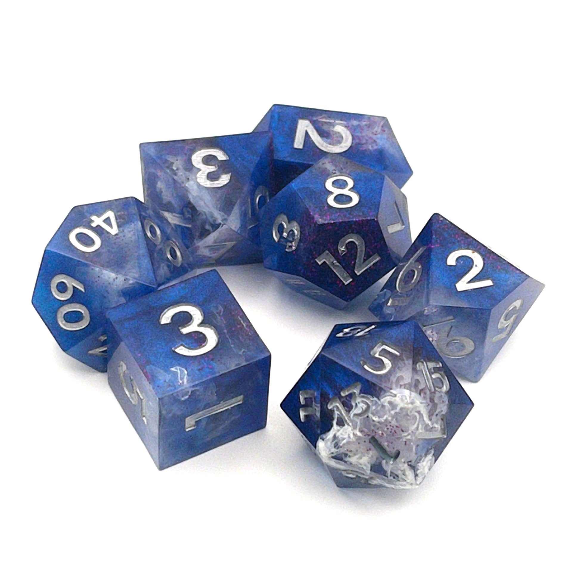 Full set of TTRPG resin dice, opaque blue in parts, with clear areas with white resin. Inked in silver