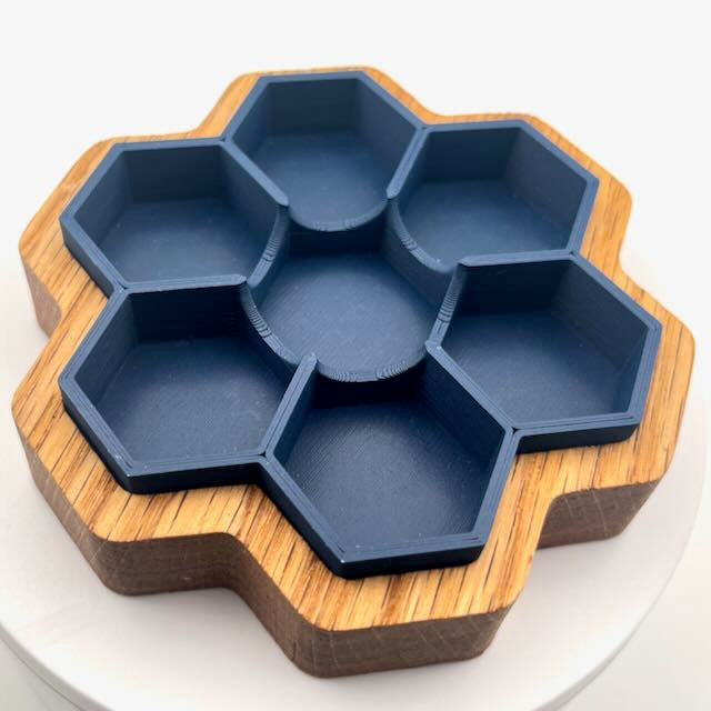 Matte navy blue PLA 3D printed hexagonal dice tray in a white oak CNC carved wooden dice tray holder