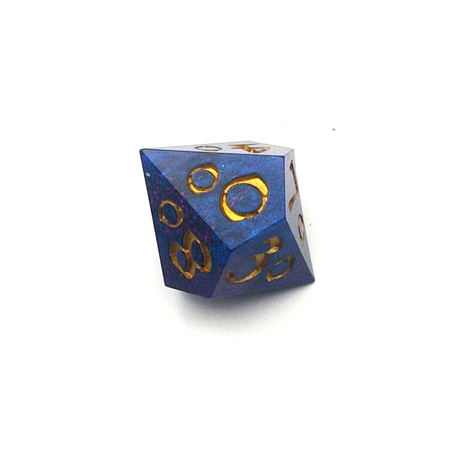 D100 chonk dice showing the 00 face. The resin is coloured with pigment powders using black, blue and red. The die is inked in gold.