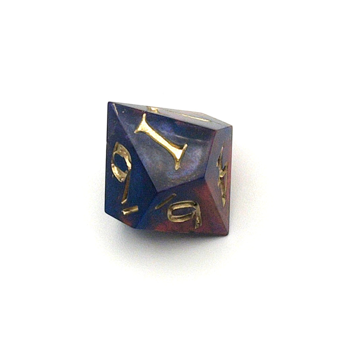 D10 chonk showing the 1 face. The resin is coloured with pigment powders using black, blue and red. The die is inked in chromed gold.