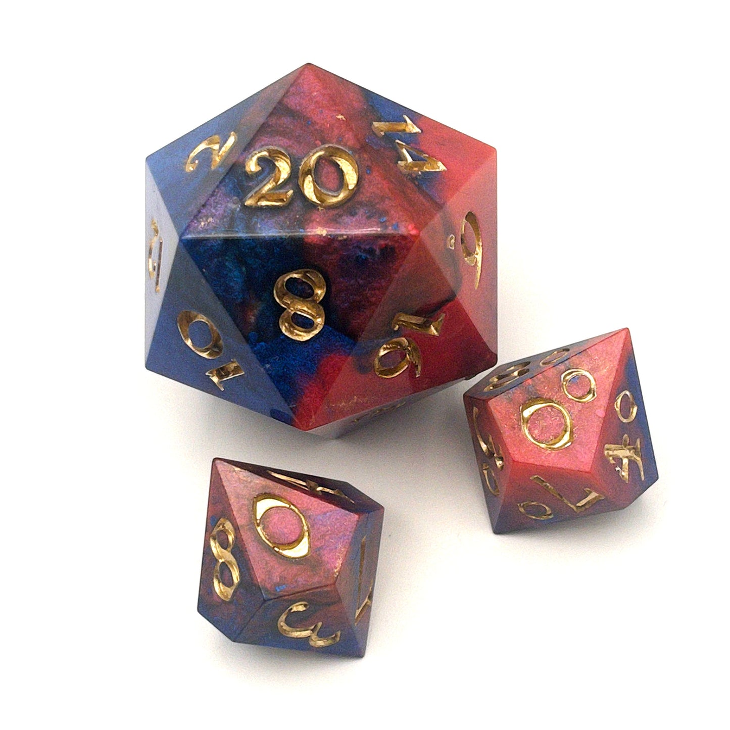 Full set of Mothership dice. The D20 is a chonk, and the D10 and D100 are regular size. The resin is coloured with pigment powders using black, blue and red. The dice are inked in chromed gold.