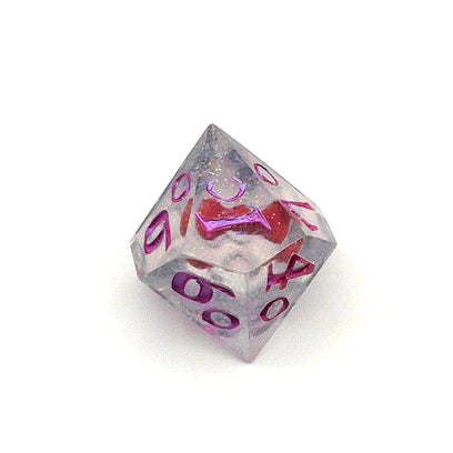D100 resin dice. Resin is transparent with translucent glitter suspended inside and a red 3D printed hair bow. These are inked in colour-shifting 