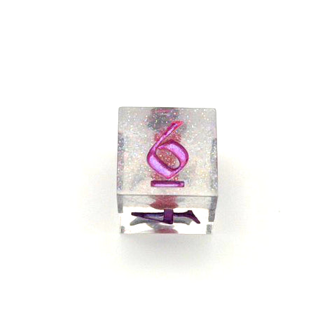 D6 resin dice. Resin is transparent with translucent glitter suspended inside and a red 3D printed hair bow. These are inked in colour-shifting 