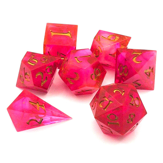 Full set of TTRPG semi-transparent resin dice, coloured with red and pink dye, with a soft blur of resin coloured with Piñata Blanco Blanco white in the centre and inked in gold