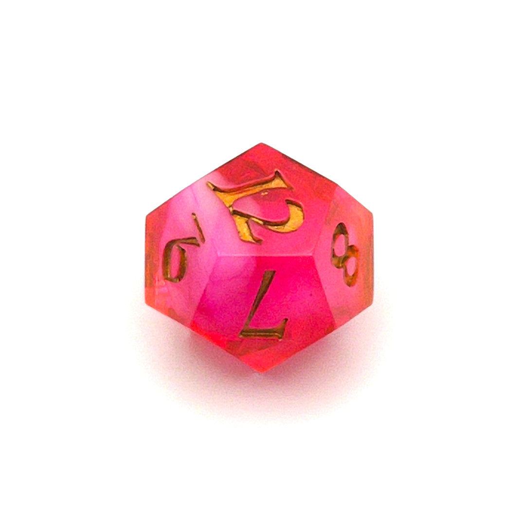 D12 semi-transparent resin die, coloured with red and pink dye, with a soft blur of resin coloured with Piñata Blanco Blanco white in the centre and inked in gold