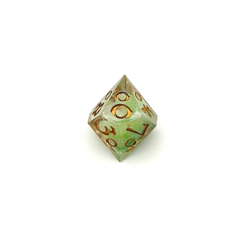 D100 TTRPG resin die, with green and white pigment cast into blanks and then shelled in clear resin and inked in Chromed Gold