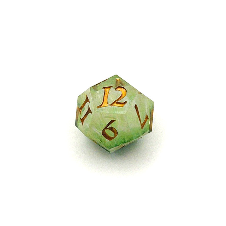 D12 TTRPG resin die, with green and white pigment cast into blanks and then shelled in clear resin and inked in Chromed Gold