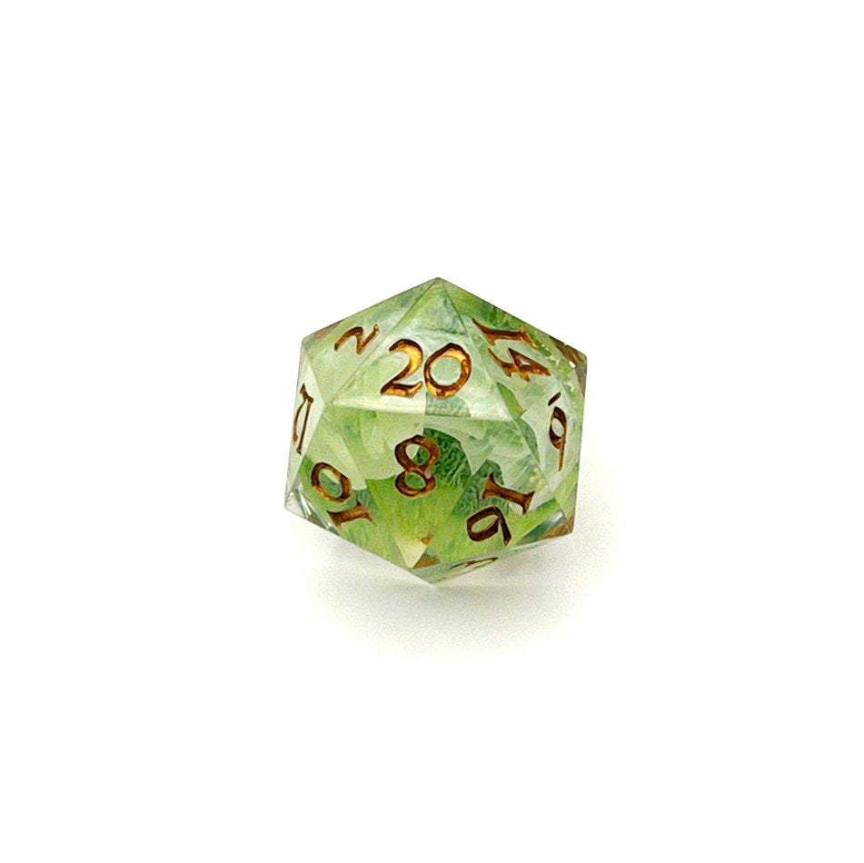 D20 TTRPG resin die, with green and white pigment cast into blanks and then shelled in clear resin and inked in Chromed Gold