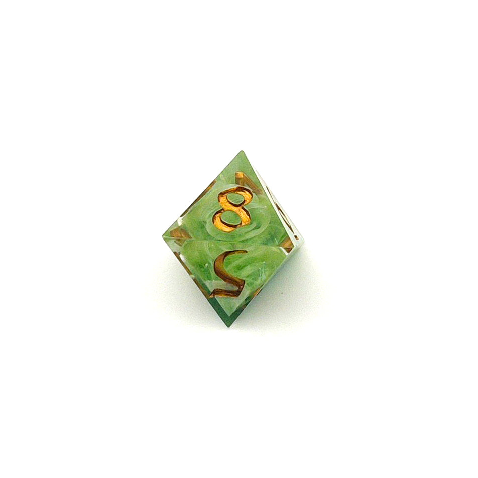 D8 TTRPG resin die, with green and white pigment cast into blanks and then shelled in clear resin and inked in Chromed Gold