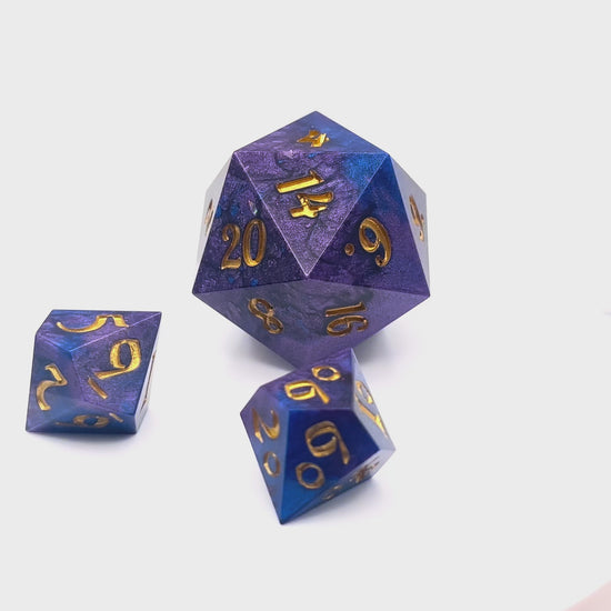Video showing a full set of Mothership dice. The D20 is a chonk, and the D10 and D100 are regular size. The resin is coloured with pigment powders using black, blue and red. The dice are inked in gold.
