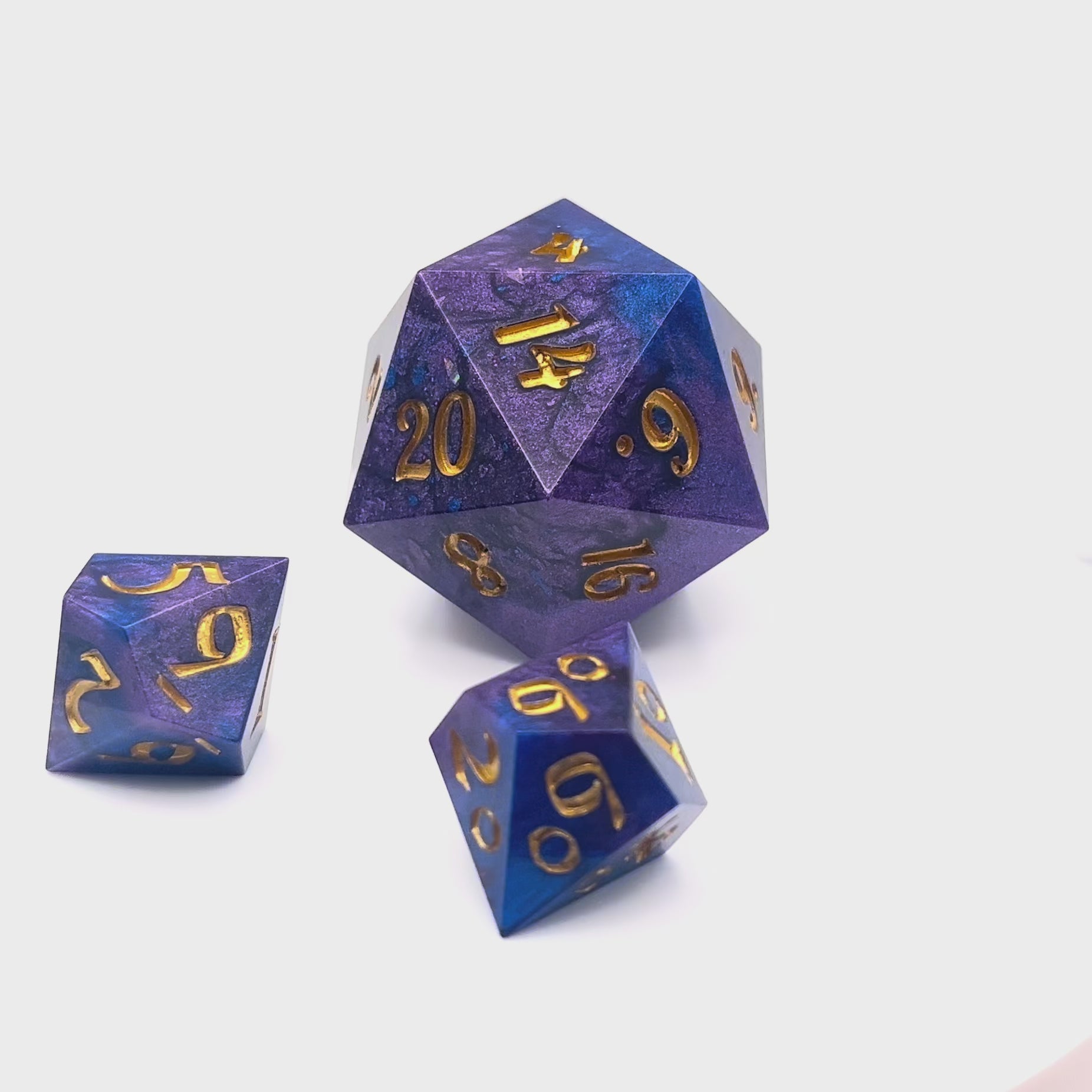 Video showing a full set of Mothership dice. The D20 is a chonk, and the D10 and D100 are regular size. The resin is coloured with pigment powders using black, blue and red. The dice are inked in gold.