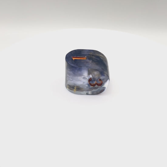 Video showing Resin infinity-shaped D4, semi-transparent using black and gold swirled dyes and inked in gold