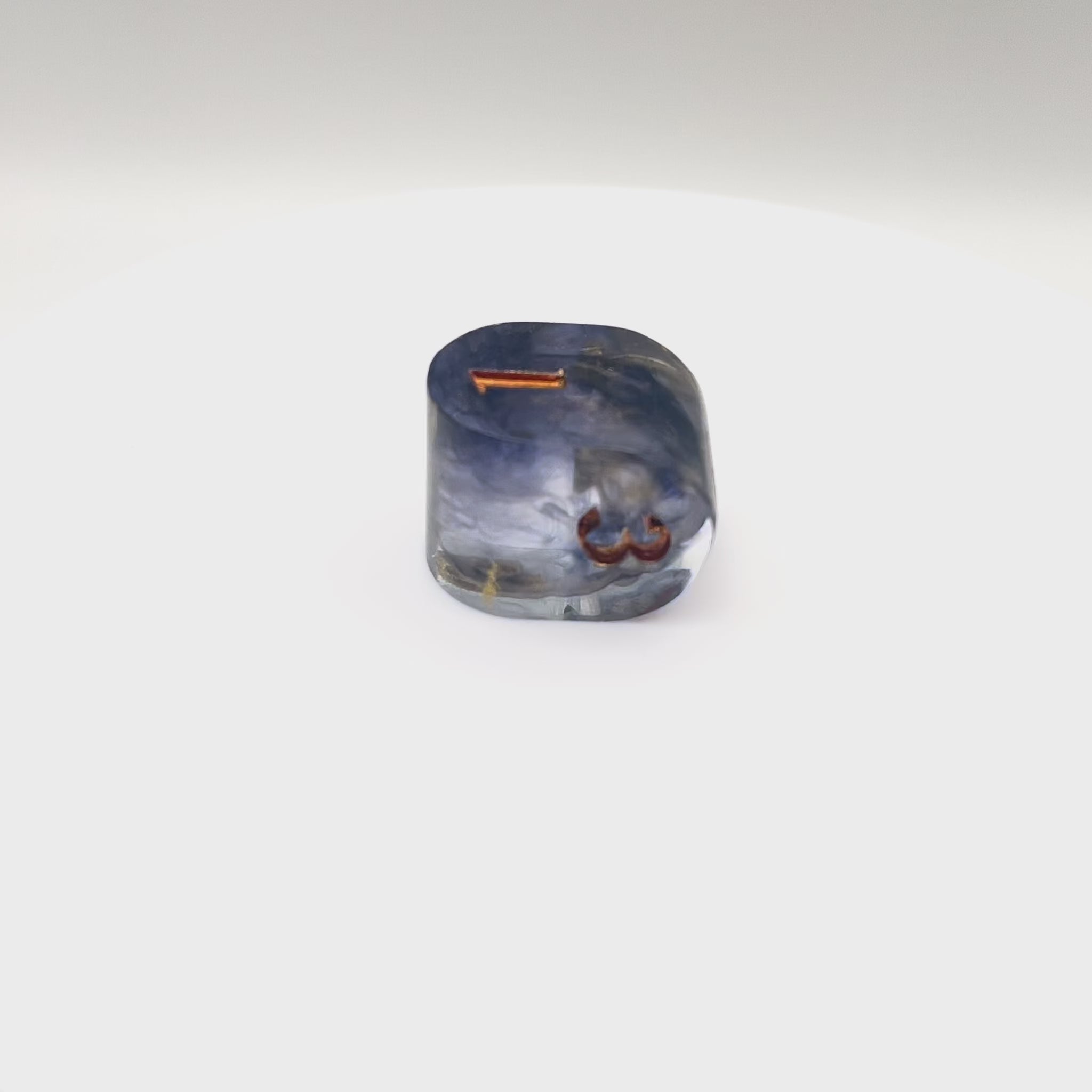 Video showing Resin infinity-shaped D4, semi-transparent using black and gold swirled dyes and inked in gold