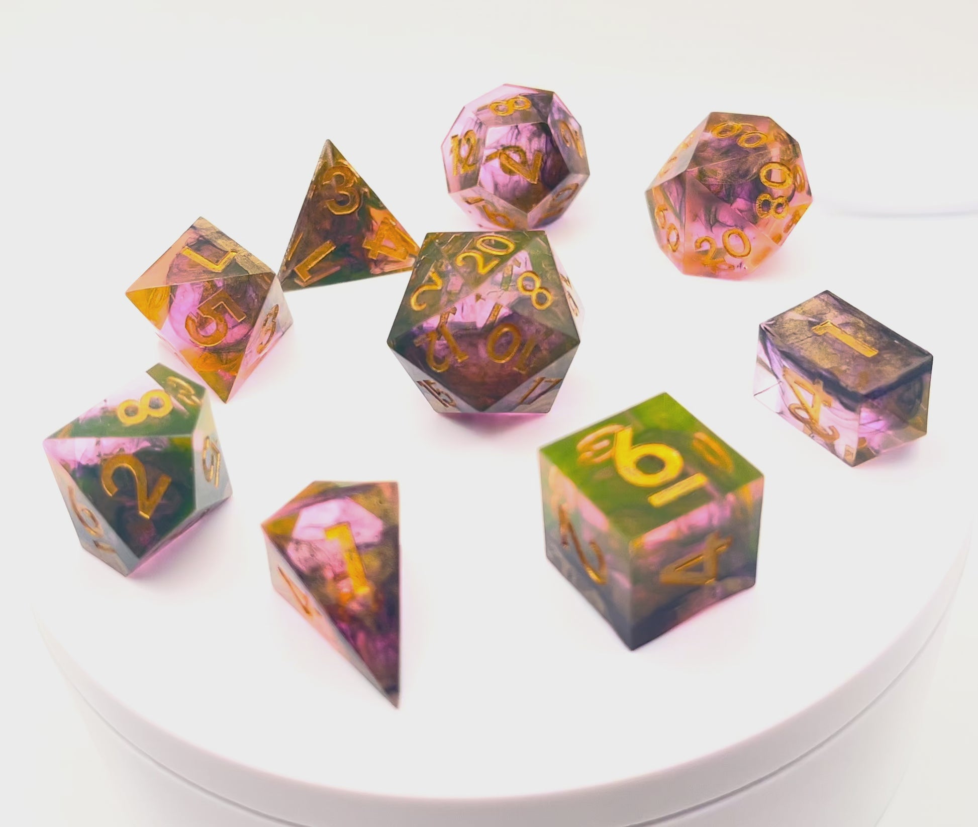 Video of Full set of TTRPG resin dice. Resin is semi-transparent pigmented with gold, black and amber dyes. These are inked in gold