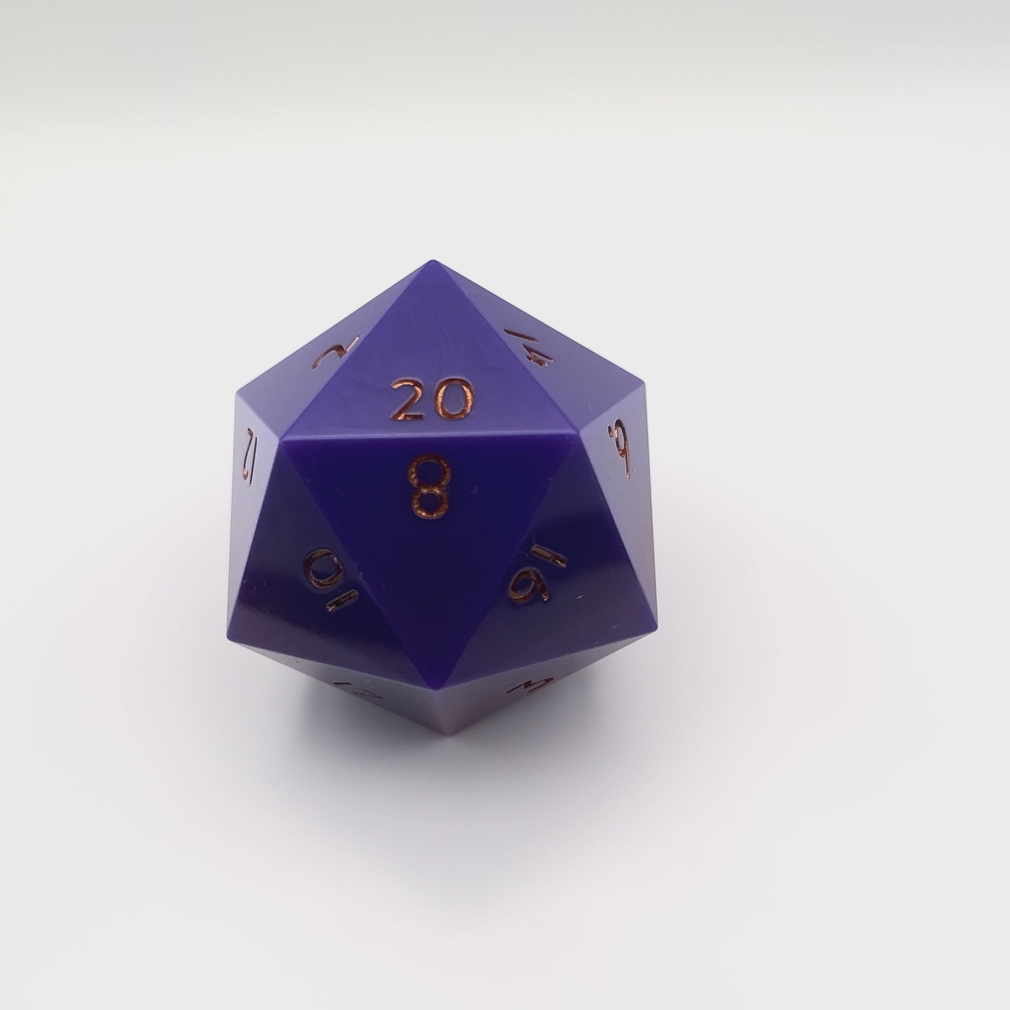 Video of Purple through red opaque pearlescent minimalist D20 chonk with gold inking on the numbers