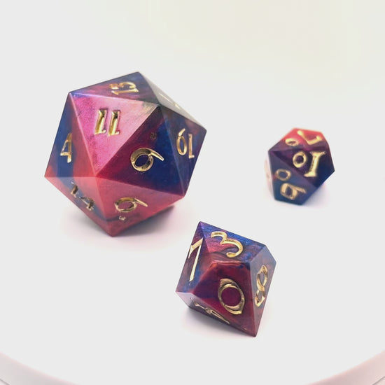 Video showing a full set of Mothership dice. The D20 is a chonk, and the D10 and D100 are regular size. The resin is coloured with pigment powders using black, blue and red. The dice are inked in chromed gold.