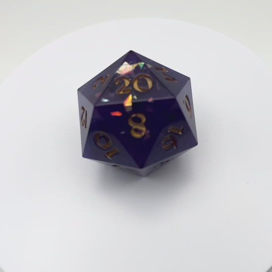 Video of Opaque purple D20 chonk with glittery shiny mylar flakes, inked in gold.