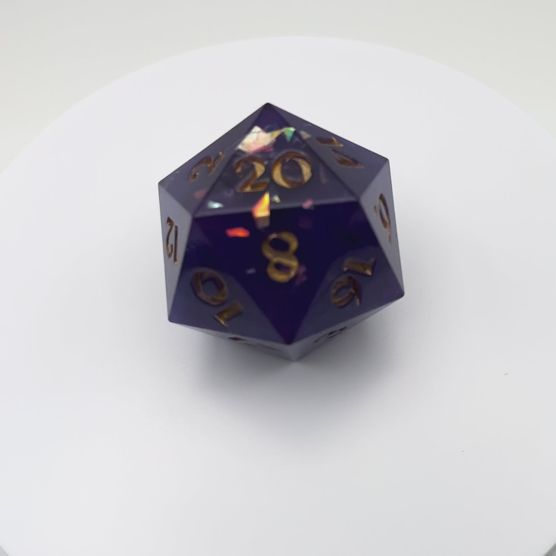 Video of Opaque purple D20 chonk with glittery shiny mylar flakes, inked in gold.