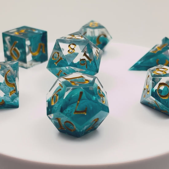 Video of Full set of TTRPG resin dice, petri-pour in white and Smurf blue, inked in Gold