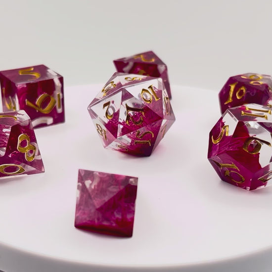Video of Full set of TTRPG resin dice, petri-pour in white and Sweet Cherry, inked in Gold